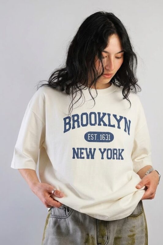 Off-white oversized long sleeve T-shirt featuring a Brooklyn New York graphic print on the front, crafted from soft premium cotton for everyday comfort.