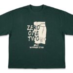 Dark green oversized graphic T-shirt featuring a "ZERO ONE TWO" front print with illustrated artwork and a soft cotton fabric.